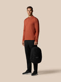 Man in burnt orange top carries a gunmetal Castore Core Backpack