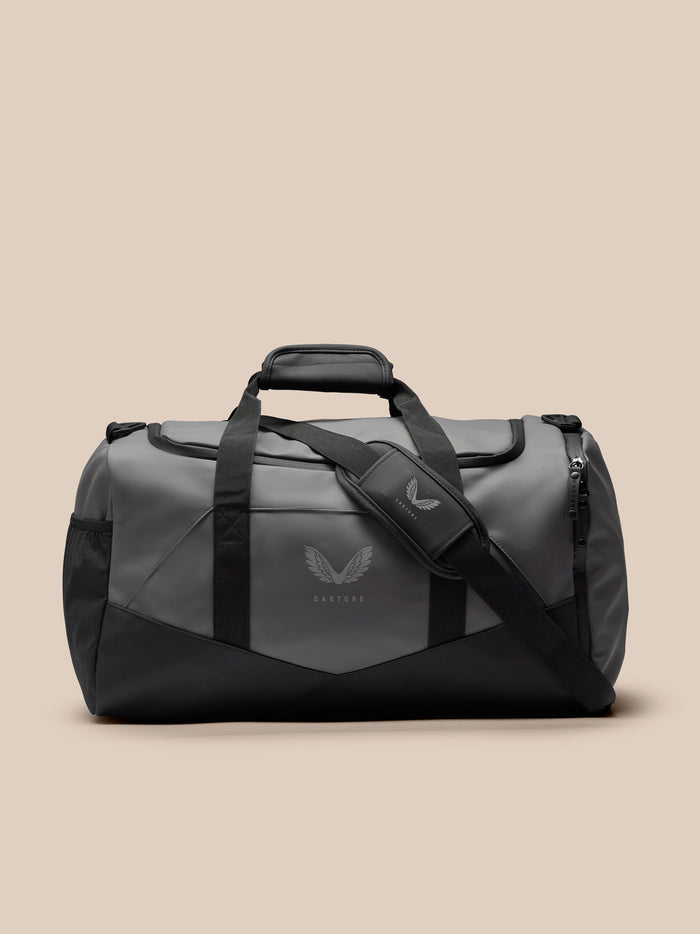 Gunmetal and black Core Holdall on a neutral background with top handles and detachable shoulder strap