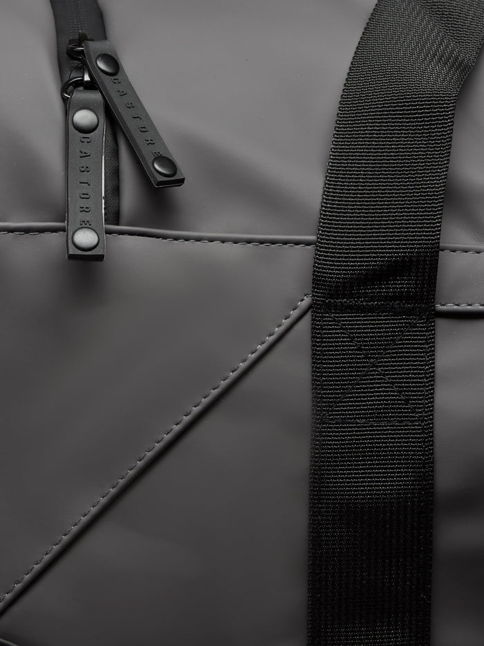Close up of zipper pulls and strap on a gunmetal Core Holdall bag