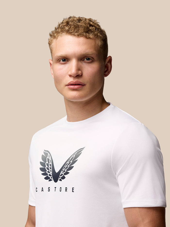 Man draagt witte Adapt Korte Mouw Grafisch T Shirt met Castore vleugellogo op borst
