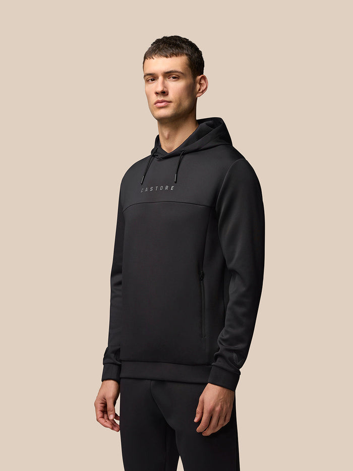 Man draagt zwarte Flex Hoodie met capuchon en CASTORE branding op de borst