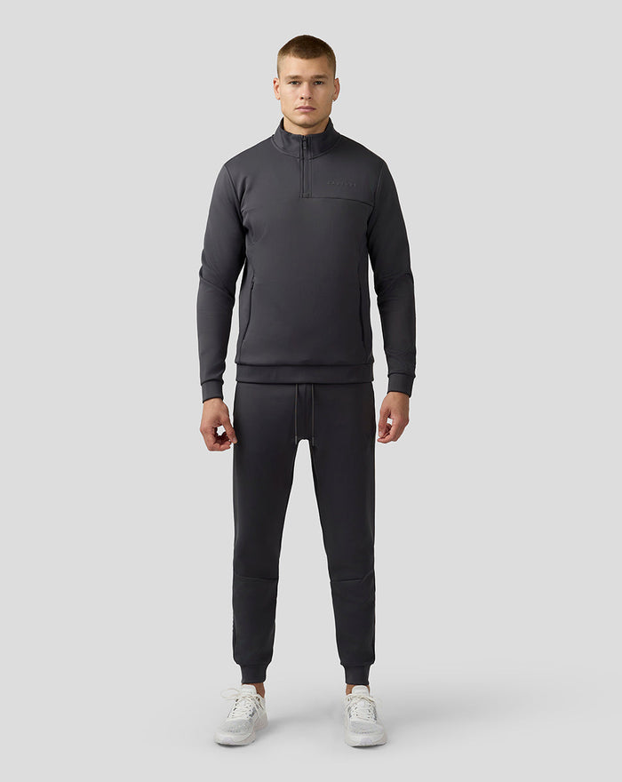 Man wearing charcoal Scuba Quarter Zip Top with a high collar and zip pockets
