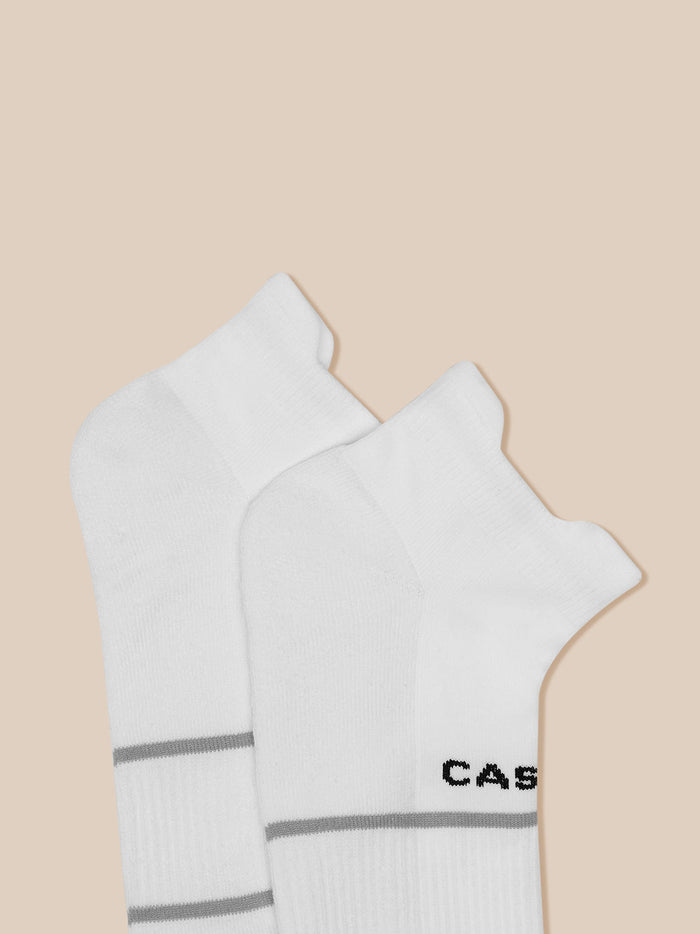 White ankle socks with subtle gray stripes on a beige background