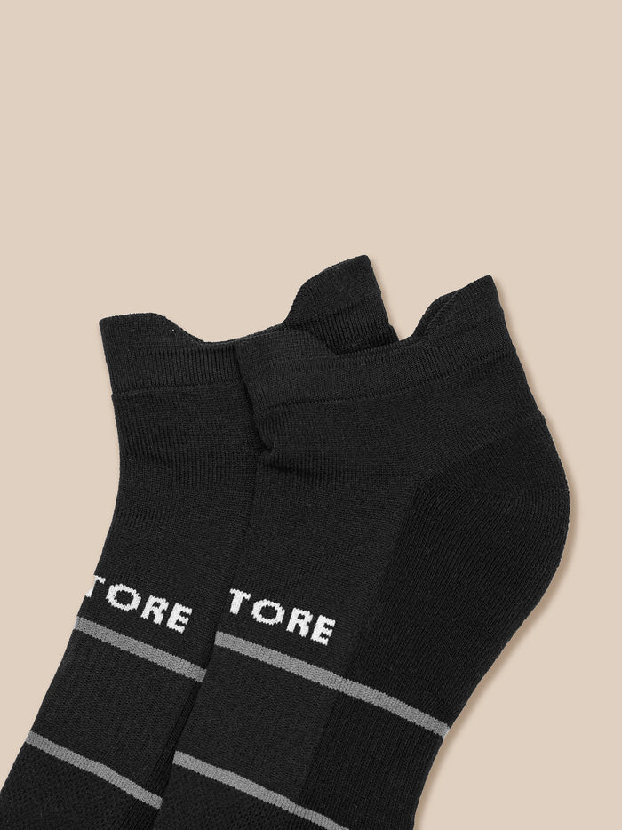 Two black ankle socks with light gray stripes and partial branding.