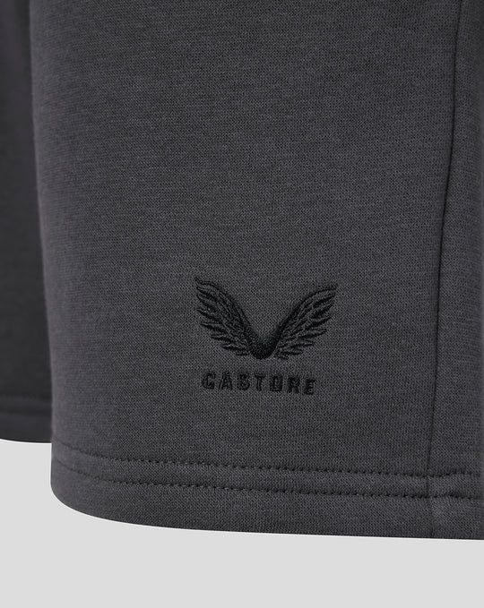 Close-up of the bottom hem showing the Castore wing logo on dark gray fleece shorts.