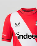 Partial view of FC Utrecht home shirt 26/27 junior with red fabric white diagonal sash crest on chest and Castore branding