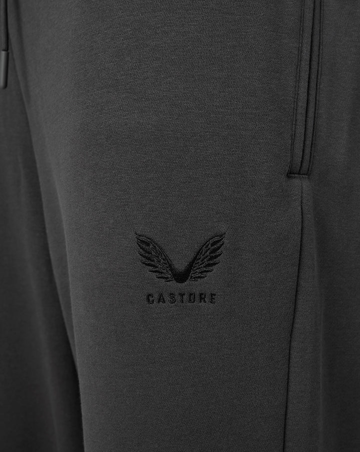Close-up of dark fleece fabric with FC Utrecht crest embroidered on the jogger leg.