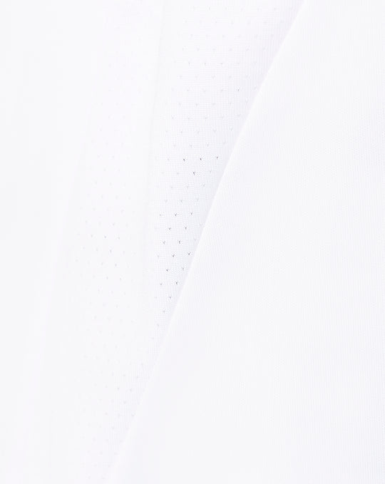 White fabric close up showing subtle perforations and diagonal paneling used in the shorts.