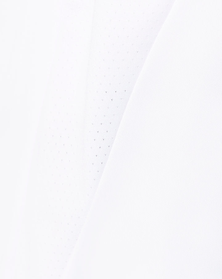 White fabric close up showing subtle perforations and diagonal paneling used in the shorts.