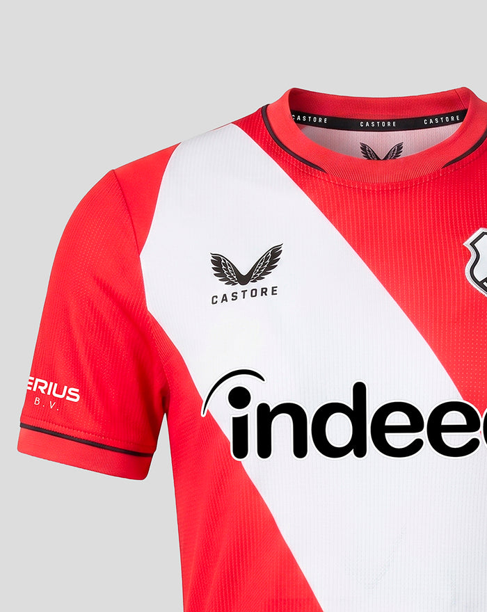 Close-up of FC Utrecht home shirt 26/27 for women highlighting a diagonal white panel on red fabric and the Castore branding at the neckline.