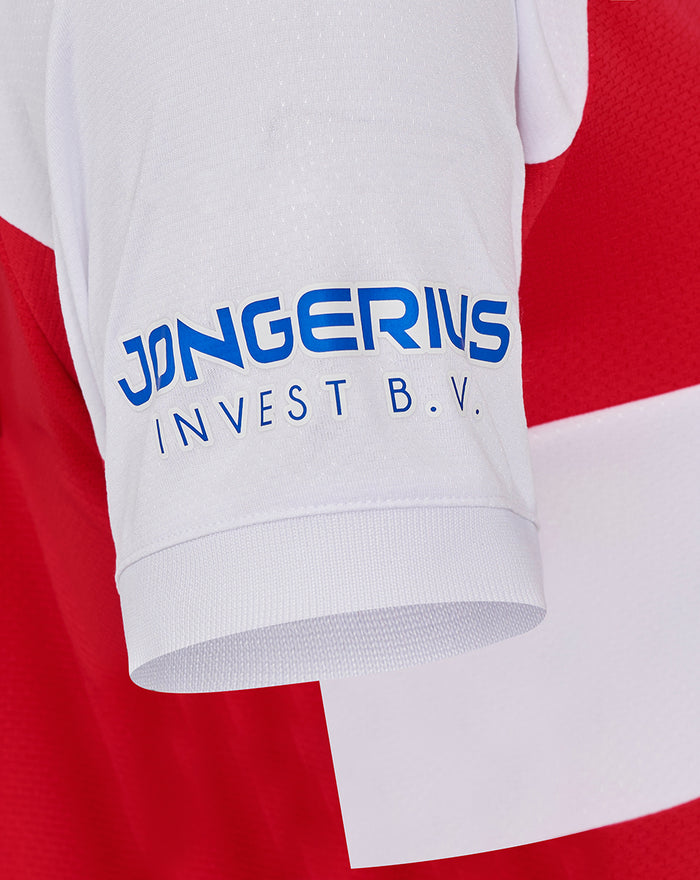 Close-up of white sleeve on FC Utrecht red and white shirt with blue sponsor logo on the front