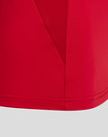 Close up of red fabric showing seam and hem on the women's training top.