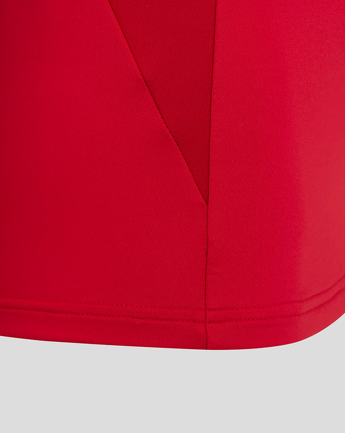 Close up of red fabric showing seam and hem on the women's training top.
