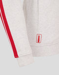 Hem area of the grey hoodie with a red stripe along the sleeve and a small red patch near the hem.