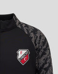 Close up of chest area showing the FC Utrecht crest on a black midlayer with camo sleeves.