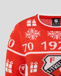 Close up of the neckline and shoulder of the red FC Utrecht junior Christmas sweater showing knitted pattern and crest