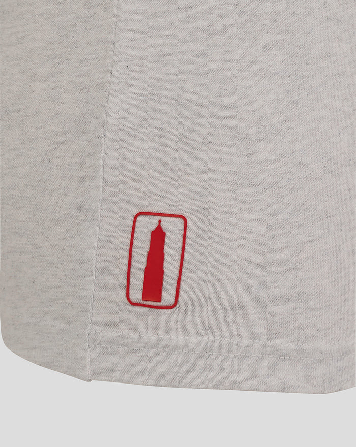 Close up of light grey fabric with red tower logo patch near the hem