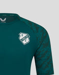 Close-up of teal green FC Utrecht training T-shirt with shield crest on the left chest and camo-pattern sleeve.