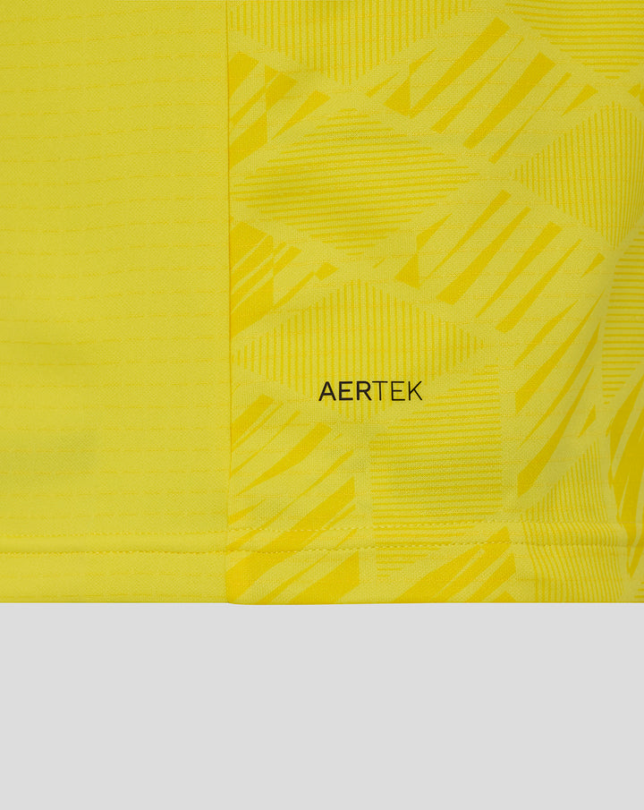 Detail van gele keepershirt stof met AerTek tekst en grafisch patroon