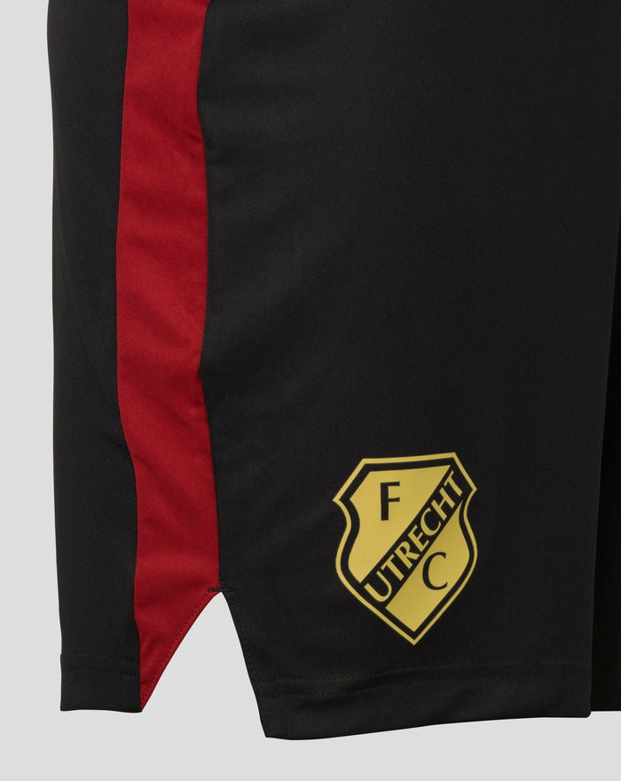 Zwarte FC Utrecht trainingsshorts met rode zijband en gouden FC Utrecht embleem en Castore branding