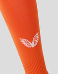 Orange goalkeeper sock close up with white logo on the lower leg