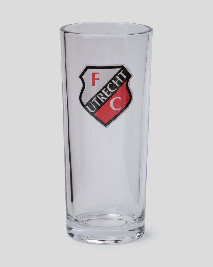 Close up FC Utrecht longdrink glass with crest visible on the front and packaging in background.