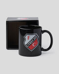 Front view of a black FC Utrecht mug with shield logo, partially inside a black box.