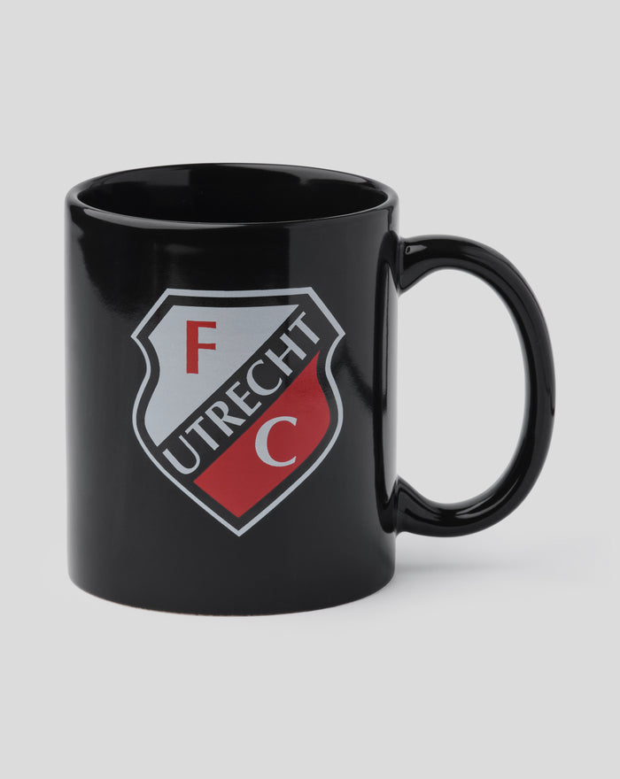 Close up of a black FC Utrecht mug showing the crest and a curved handle.